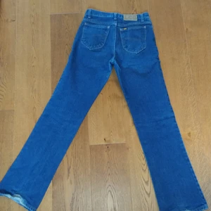 Lee jeans - Säljer dessa asnygga mörkblå / mellanblå jeansen från Lee. De är lite utsvängda, flare / bootcut. 100% bomull. Bra kvalité! I fint skick, endast använd fåtal gånger. I storlek W28 eller W29? Passar även på mindre storlekar beroende på hur man vill att de ska sitta! De är för långa för mig som är 167 ish. Skriv för frågor❤️