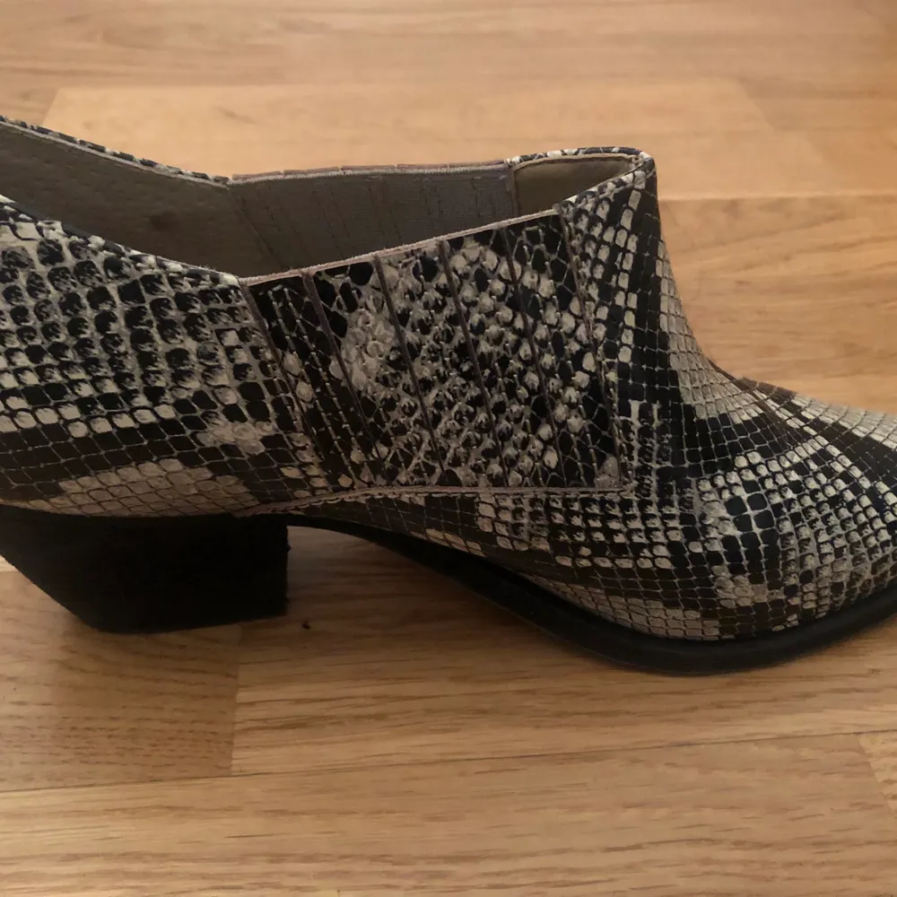 Ankle boots, made from real leather with a snake print with a oak wooden heel. Size 40. They are too small for me. . Skor.