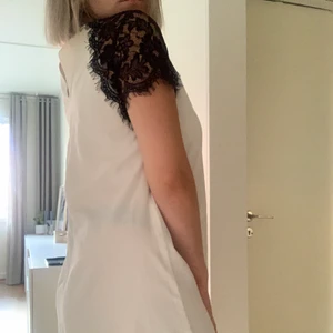 Klänning med spets - Vit klänning med svart spets på axlarna. Kroppsformad men inte åtsittande - supersnygg med ett skärp i midjan eller utan!👌🏽 Köpt i Italien, använd 1-2 gånger.