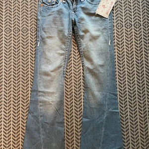 Skitnsygga True Religion Jeans - Skitsnygga true religion jeans som är HELT NYA!                    Stl. 27 i midjan ( längden passar mig som 173cm lång)        Midjemåttet är 76cm och innerbenslängden är 78cm                                  Köptes för ca 3000kr och säljes från 400kr!                         BUDGIVNING I KOMMENTARERNA.                   