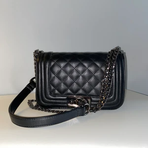 Axelremsväska  - En svart axelremsväska från Gina tricot. Det går att ha axelremmen både lång och kort (dubbelvikt). Liten defekt finns, skickar bild på defekten privat vid intresse.