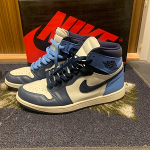Air Jordan 1 Obsidian - Säljer mina Jordan 1 obsidian, de köptes april 2020 och är därför använda. Condition 7/10. Skoboxen och extra snosnöre (ljusblåa och mörkblåa) ingår, dock inget kvitto då skornas är över 1 år gamla…