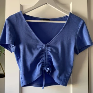 Drawstring topp - En super fin blå topp ifrån zara i ribbat tyg med en drawstring i mitten där man kan dra åt hur kort man vill att den ska vara. Mycket bra skick då den bara använts 2 gånger💕
