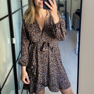 Omlottklänning från Sisters Point - Jättefin klänning i omlottmodell med mönster i fina färger. Storlek M men passar en S bra. Oanvänd fint skick!  