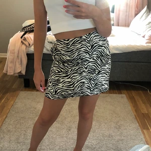 Zebra kjol med volang - Säljer en zebra kjol med en volang ifrån Lindex, volangen ser man inte ser så jätte tydligt på bilden så bild kan skickas vid intresse, storlek 158/164, sällan använd så därför väldigt bra skick, frakten ingår i priset!