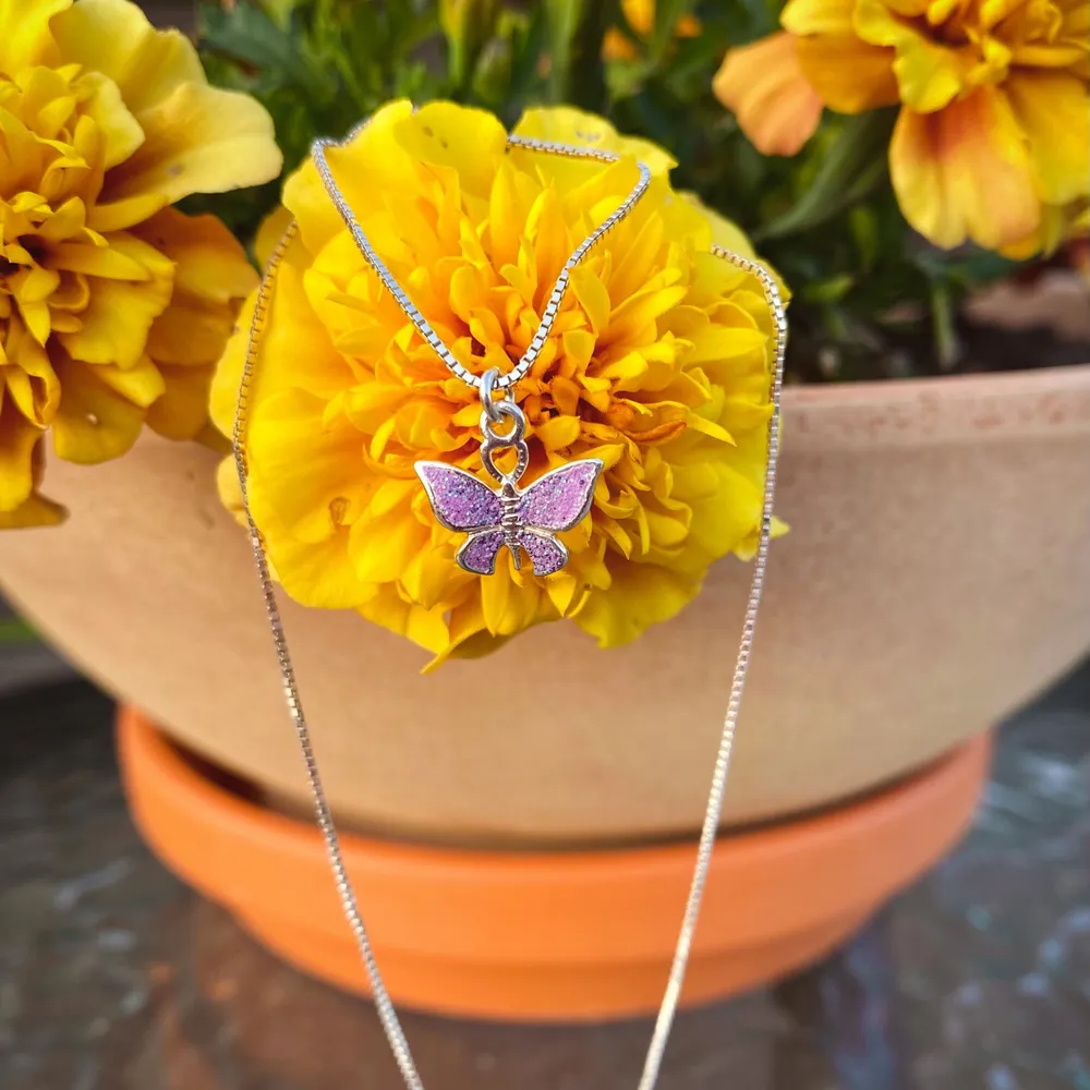 Ett halsband med en lila glittrig fjäril på. Kedjan är 35 cm lång  //Samfraktar gärna om du köper mer än en sak 😊  . Accessoarer.
