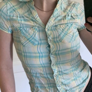 Söt skjorta - Jätte din rutig glittrig skjorta med knappning fram och fickor, som tyvärr är för liten för mig runt bysten. Är en barnstorlek (146) Vilket därför passar bättre till en XS eller mindre. Köparen står för frakt! (Frakt pris varierar beroende på vikt och om du vill ha spårbart eller ej!). 💕💕