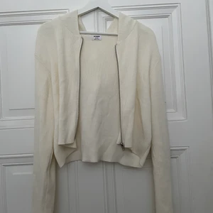 Söt stickad kofta  - En supersöt stickad kofta i off-white med dragkedja och luva. Lite kortare modell och jätteskönt material. Perfekt till våren och sommaren ✨ Frakt ingår i priset! 