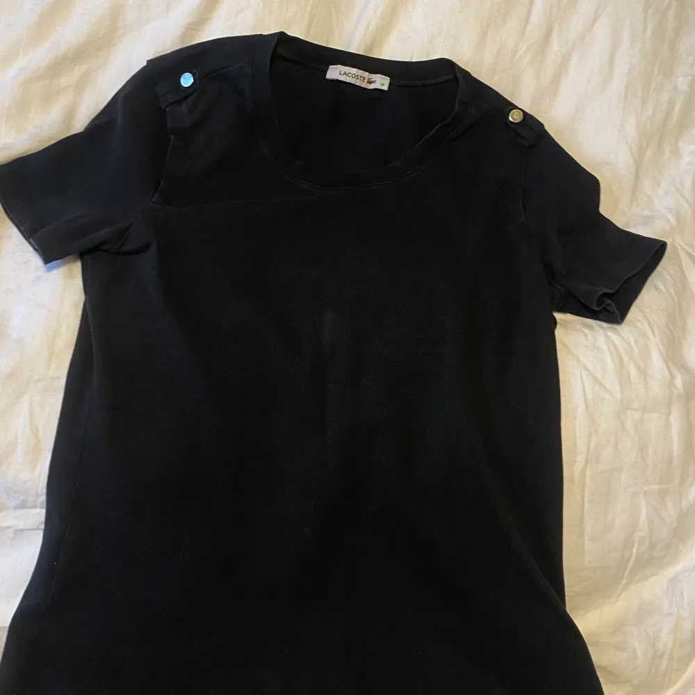 Jättesnygg svart Lacoste tröja med knappdetaljer.. T-shirts.