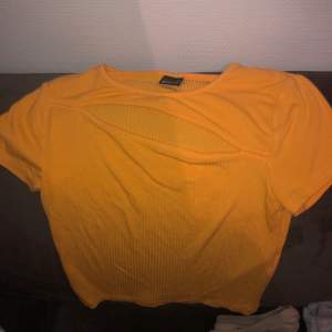En neon orange t-shirt med öppning vid bröstet från Gina tricot i str xs