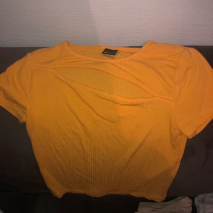 En neon orange t-shirt - En neon orange t-shirt med öppning vid bröstet från Gina tricot i str xs