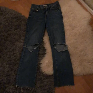 Gina tricot jeans blåa med hål  - Ett par jätte snygga jeans från Gina tricot som tyvärr är för små för mig. Hålen har jag klippt själv. Köparen står för frakten💕