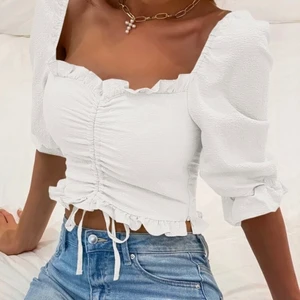 Vit blus  - Vit blus med en dragsko och lite volym i ärmarna. Tyvärr för liten för mig, så den har inte blivit använd något bara vättad en gång. Det står storlek medium men den passar nog bättre på xs/s. 