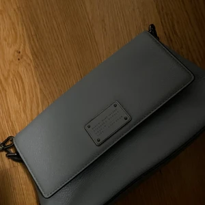 Marc Jacobs - Axelremsväska - Helt oanvänd Marc Jacobs axelremsväska. Färg: Himmelsblå/ljusgrå. DM för fler bilder. Superfin men föll mig inte i smaken när jag fick den som present. Nypris ca 2500.