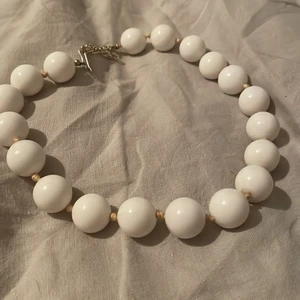 Jag säljer det här gammaldagsa halsband. - Det här har används ett fåtal gånger, från en gammal tid. Det vita halsbandet med stora vackra kulor är nämligen från 19 talet. 