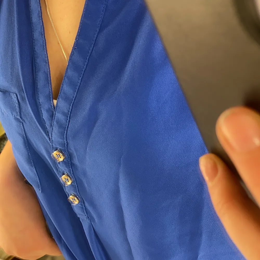 Blå blus med urringning från H&M. Använd men i bra skick.. Blusar.