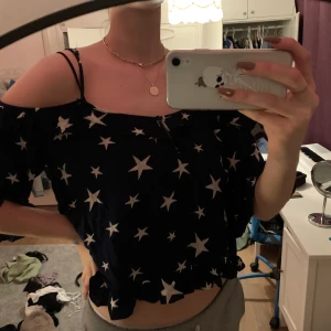 Blus  - Mörkblå blus i lätt o mjukt material men volang och stjärnor.