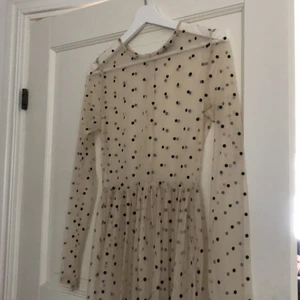 Svartprickig överklänning från Lace & Beads - Skir överklänning som är riktigt snygg över en svart enkel klänning exempelvis. Passar allt från XS-L beroende på hur du vill att passformen ska vara. Rekommenderar ett midjebälte till ifall du vill framhäva figuren! Hör av dig om du har fler frågor!