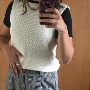Vit stickad tröja - Säljer den här stickade tröjan. Det är från början en långärmad stickad tröja men jag har tagit bort ärmarna och gjort om den till en kortärmad tröja/väst. Den är rätt tunt stickad och passar bra över en annan tröja eller en skjorta. Skicka ett meddelande för bättre bilder! 