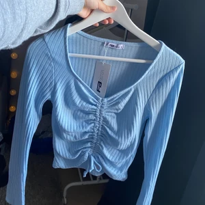 Blå tröja - Jättefin top i den perfekta blå färgen! Oanvänd med prislapp kvar, kan skicka bild hur den ser ut på om det önskas. Frakt tillkommer 48💕