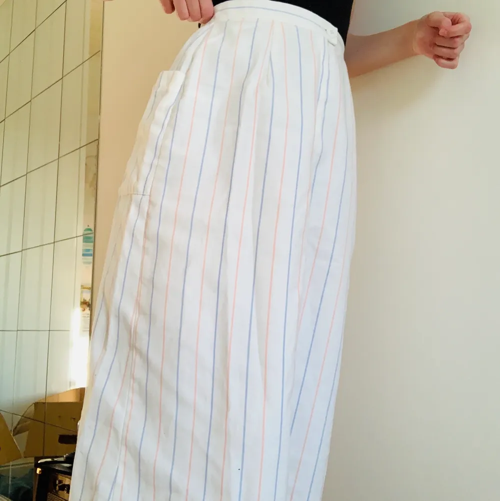 Fin randig kjol, ganska lång men inte hela vägen ner till fötterna. Har en ficka och knapp+dragkedja.. Kjolar.