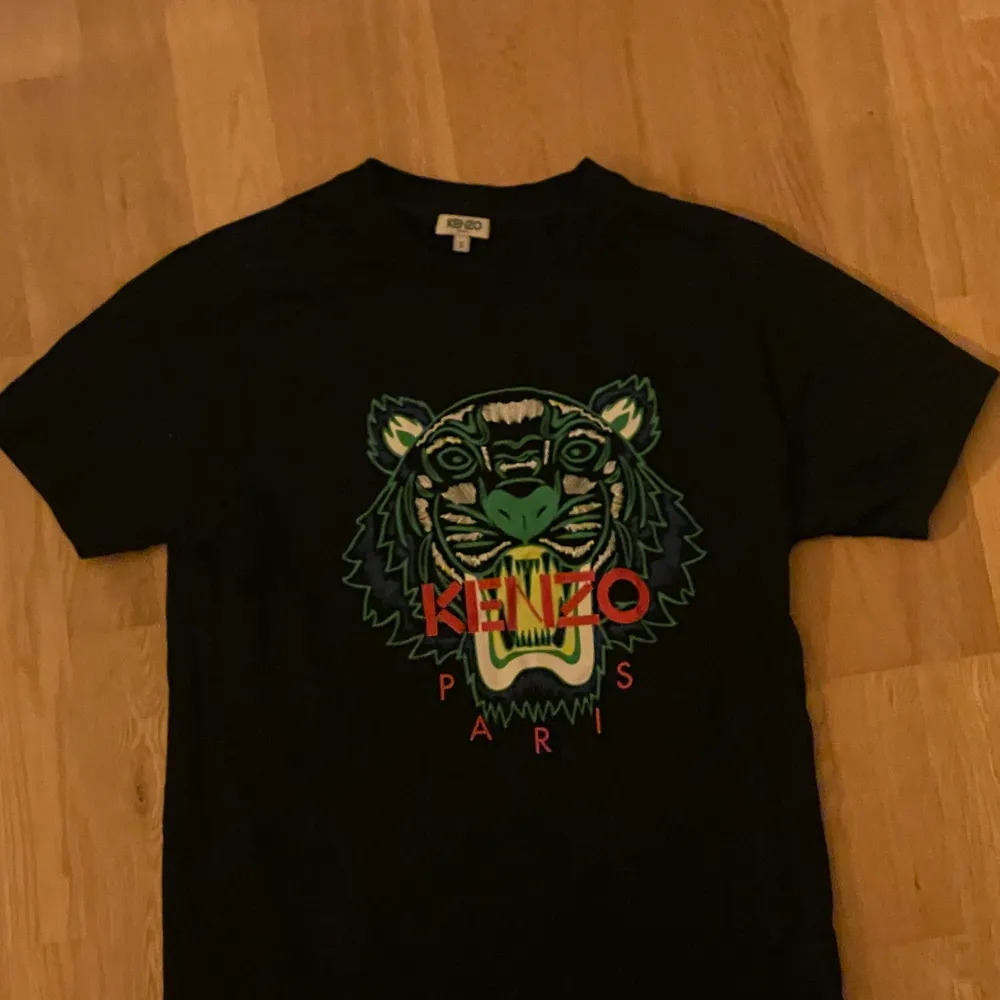 Säljer min svarta Kenzo T-shirt med tigern på bröstet  i storlek S, den är i bra skicka knappt använd, nypris 1050kr, vill ni ha fler bilder eller är det något du undrar över är det bara att höra av sig☺️. T-shirts.