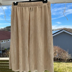 Kjol med skimmer - Oanvänd skimrig kjol i fin nude nyans! Storlek S. Säljes pga. Flytt