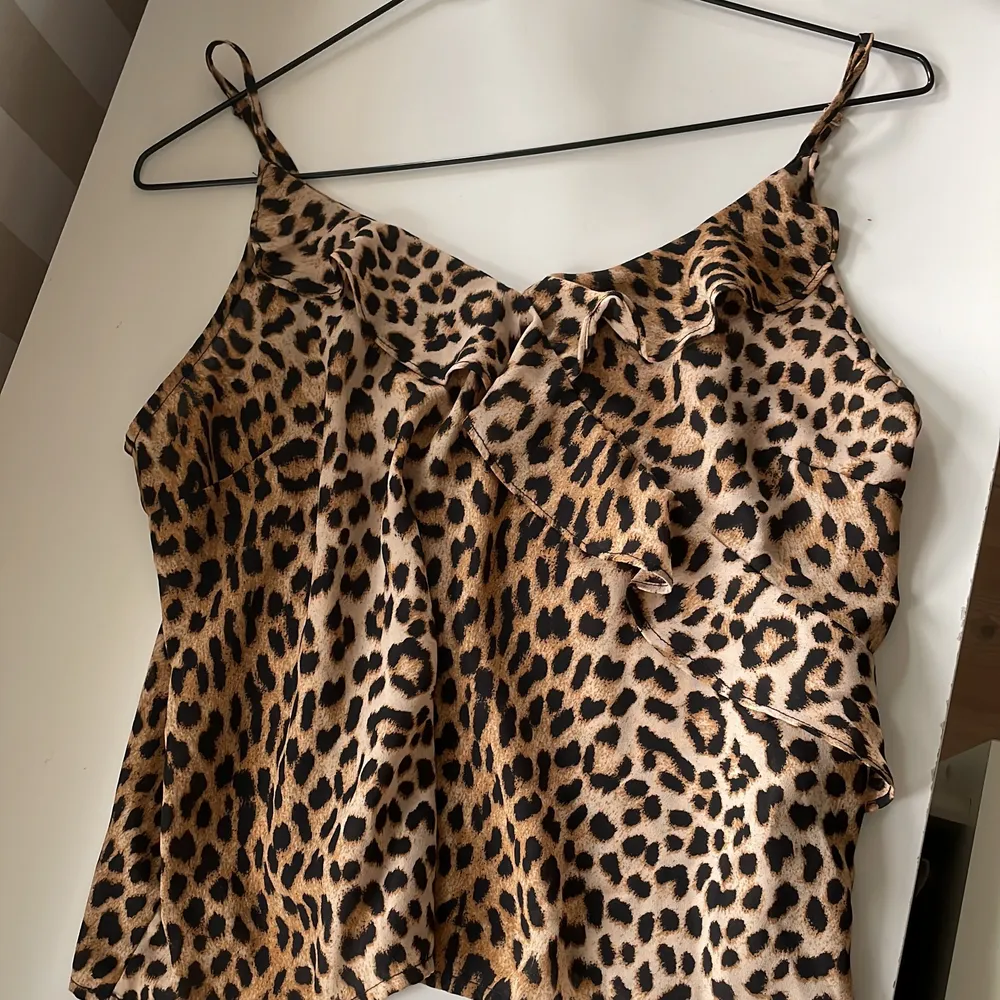 Ett fint linne till sommaren från Gina tricot. Leopardmönster, brunt/svart/beige. Kommer inte till användning längre och är i mycket bra skick. Justerbara band. Stl 36, passar även mindre storlekar. . Toppar.
