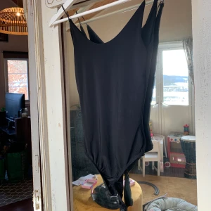 Svart body - Bik Bok - Svart tight body från Bik Bok. Baddräktsmaterial nästan. Aldrig använd då jag köpte för liten storlek 🤦🏼‍♀️. Djup i ryggen och tunna axelband.                                                                         
