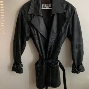 Skinnjacka vintage äkta skinn - En vintage skinnjacka med bälte, storlek S. Stor krage lite oversize, passar även på en M. Visst slitage finns (snyggt slitage på lädret) lite hål i fodret på ena fickan. (Inget som syns).  