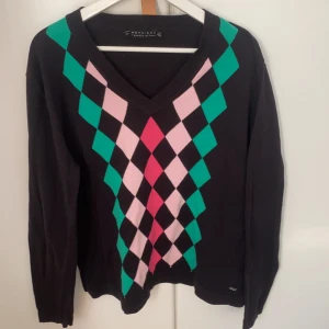 Stickad svart tröja med färgat mönster - En svart stor stickad tröja, med v ringning o fint mönster i flera färger. 
