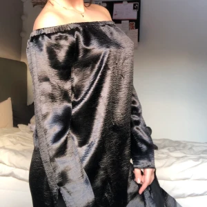 Nly trend svart klänning, storlek 36 - Nly trend svart glansig klänning i gott skick. Går även att vika upp som tröja