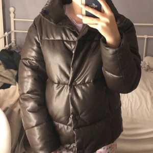 Puffjacka brun - Lägger upp igen! Superfin och varmt till vintern, säljer då jag gärna vill ha en vinterjacka med huva! En puffjacka i skinnimitation, väldigt populär på vintern! (Första bilden är med blixt). De andra bilderna visar hur den sitter och hur färgen är. Ordinarie pris 700kr! Kom med egna bud(frakt ingår inte)