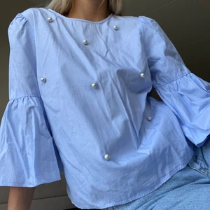 Blus med pärlor - Gullig blus med pärlor fram i en superfin babyblå färg. Kortare volangärm. Använd fåtal gånger, fint skick.