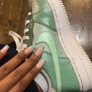 Nike Air force 1 målade grönt i olika nyans. Använda men är fräscha, fram på skorna har det löstnat lite färg men de ser fortfarande bra ut och är i bra skick.