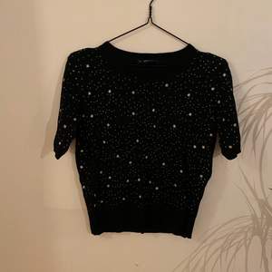 Svart T-shirt från Zara i väldigt finstickat material med stjärnor och glitter. Storlek M.