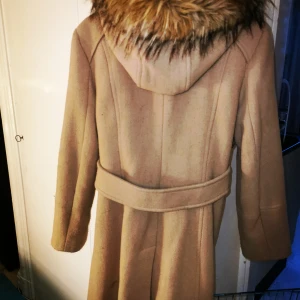Calvin Klein ullkappa m päls LARGE - Jättefin beige kappa med stor fin päls    (dock ej äkta päls ) i large.  Kan passa medium med. . Väldigt varm och vacker. Guldfärgade detaljer  Första bilden stämmer bäst i färg på kappan