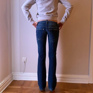 Lågmidjade DSQUARED byxor - Jag säljer nu ett par jättefina och välbevarade y2k byxor. De är lågmidjade som ni ser på bilden, märket är DSQUARED. Modellen på bilden är 168. Innerbenslängden är 84. Dem är storlek 40, men passar mer som 36/38. Italiensk storlek. Köpta på Cenino Donna i Helsingborg för 5000kr. Skicka jättegärna meddelande om ni har frågor eller vill ha fler bilder🥰