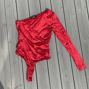 Bikbok body - FINASTE röda bodyn i sammetstyg!!!!! Hur snygg som helst till ett par blåa jeans. Den är one shoulder och har en lång arm. Bra kvalitet och enbart testad. Fodrad med två lager🥰🥰🥰🥰