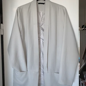 Kavaj i ljusgrått - Bekväm och luftig kavaj utan knappar i crêpetyg och oversizemodell.