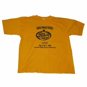 Daville Symphony Orchestra - Vintage Tee - En sjukt Nice mörkgul/gul tröja med ett coolt rintigt vintage svart tryck som finns över bröstet men även på ryggen. Den är thriftad för länge sedan. Tröjan är skapad 2002 och är därför perfekt för en tidig 00-tal vibe