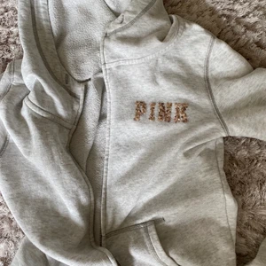 Grå munkkofta med detaljer  - skitcool grå hoodie med dragkedja med text där bak och fram, bra skick och inte använd så mycket. St XS men skulle säga funkar upp till M