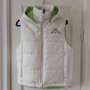 Kappa väst - Trendig väst från Kappa vitt med limegröna detaljer. Huvan går att ta loss. Snygg att dra ihop kanten längst ned o vika upp. Finns även en innerficka. Fri frakt!