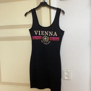 H&M kort tight klänning - Kort klänning med tight passform från H&M. Svart med ”vienna” tryck. Strl 36.