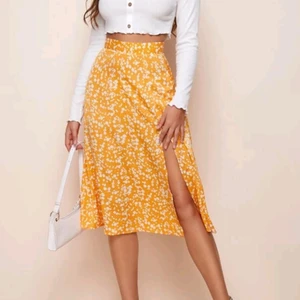 Gul midi kjol med blommor - Hej! Köpte kjolen från shein men den var tyvärr lite för liten i midjan på mig och jag säljer därför denna vidare. Endast testad, nypris är 89 från hemsidan och den är i storlek M men passar nog mer en small 