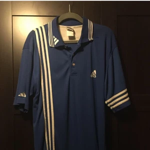 Adidas topp blå - Topp med logoen på armen, brystet og kragen pluss de tre ikoniske stripene tre ulike steder også. Kjøpt i Amsterdam