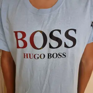 Oanvänd Hugo Boss t-shirt med centrerad text och ljusblå bakgrund. Simpel design funkar med det mästa. Framhäver dina armar och är väldigt behaglig att ha på sig.       (!Tar häldst swish!)