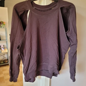 Sweatshirt - Mörkgrå sweatshirt med utskurna detaljer. Aldrig använd. Från djur och rökfritt hem. Kan skickas mot fraktkostnad 