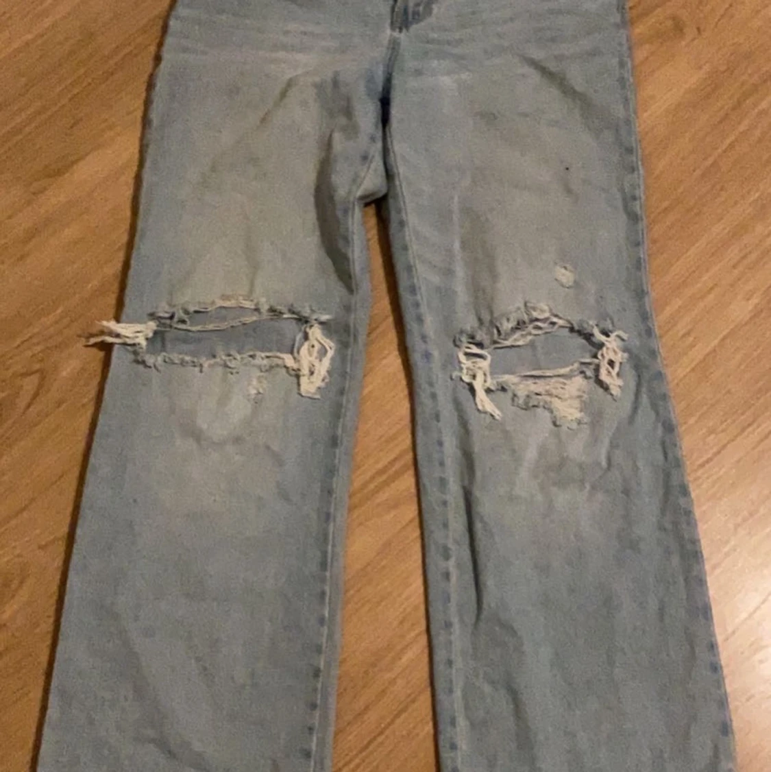 Ett par ljusblåa jeans med hål i