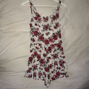 Vit playsuit med rosor  - Jättefin playsuit med rosor från H&m. Storlek XS och jättebra skick. Ser ut som en klänning på, en riktig sommardröm💖